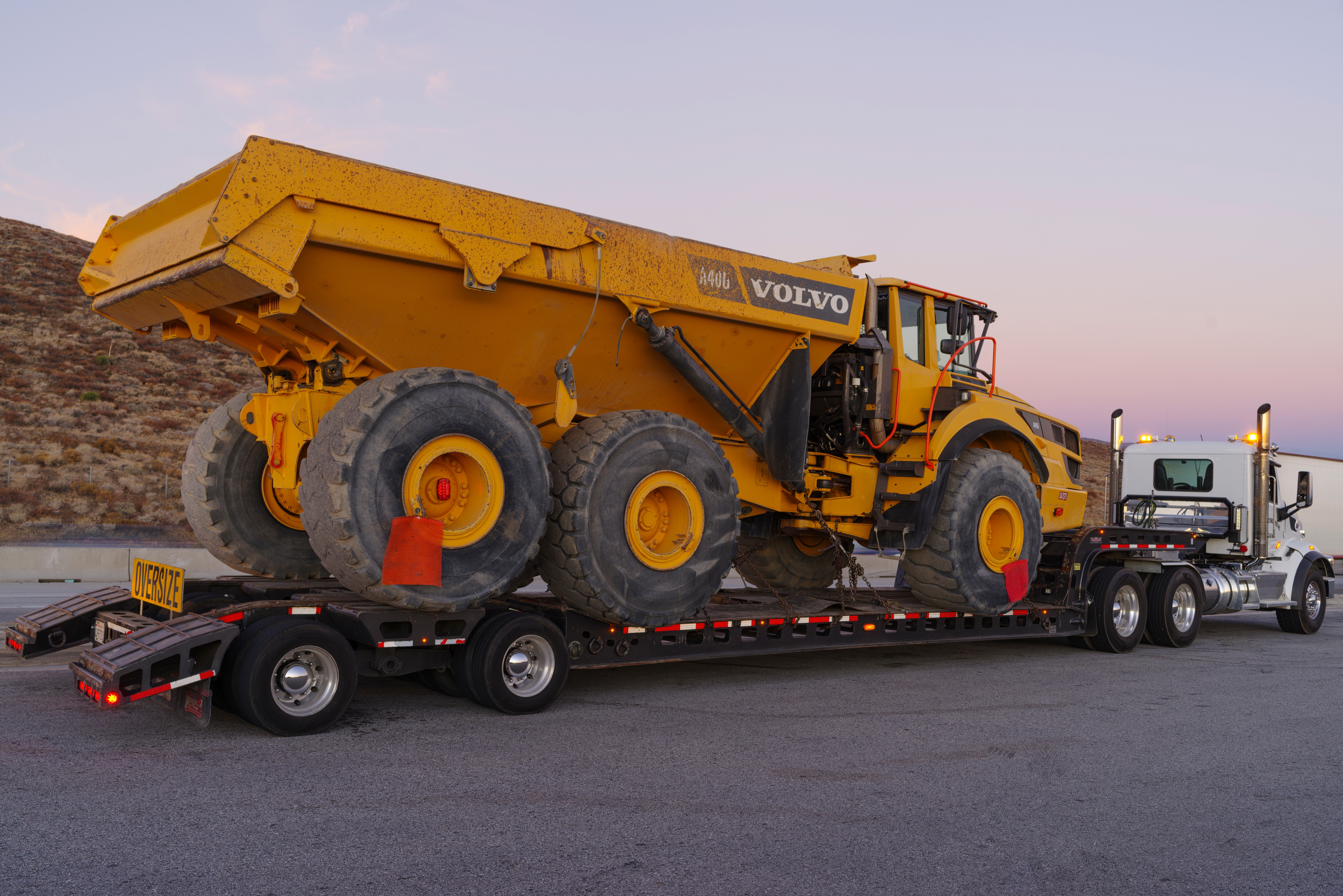 Heavy equipment secured on a trailer for insured transport